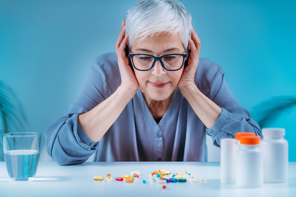 Woman looking at medications that have lead to polypharmacy. 