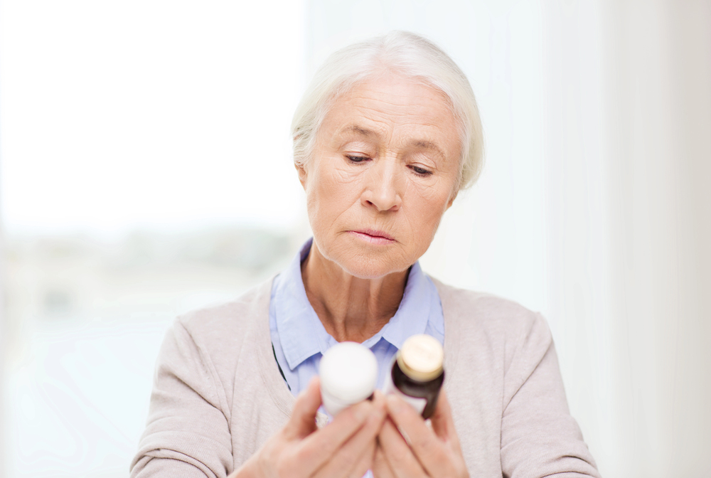 woman looking at bottles to determine if she could be having delayed medication side effects